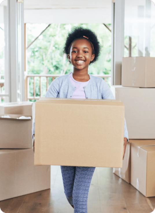 Happy child with boxes ready to move into new home Happy child with boxes ready to move into new home
