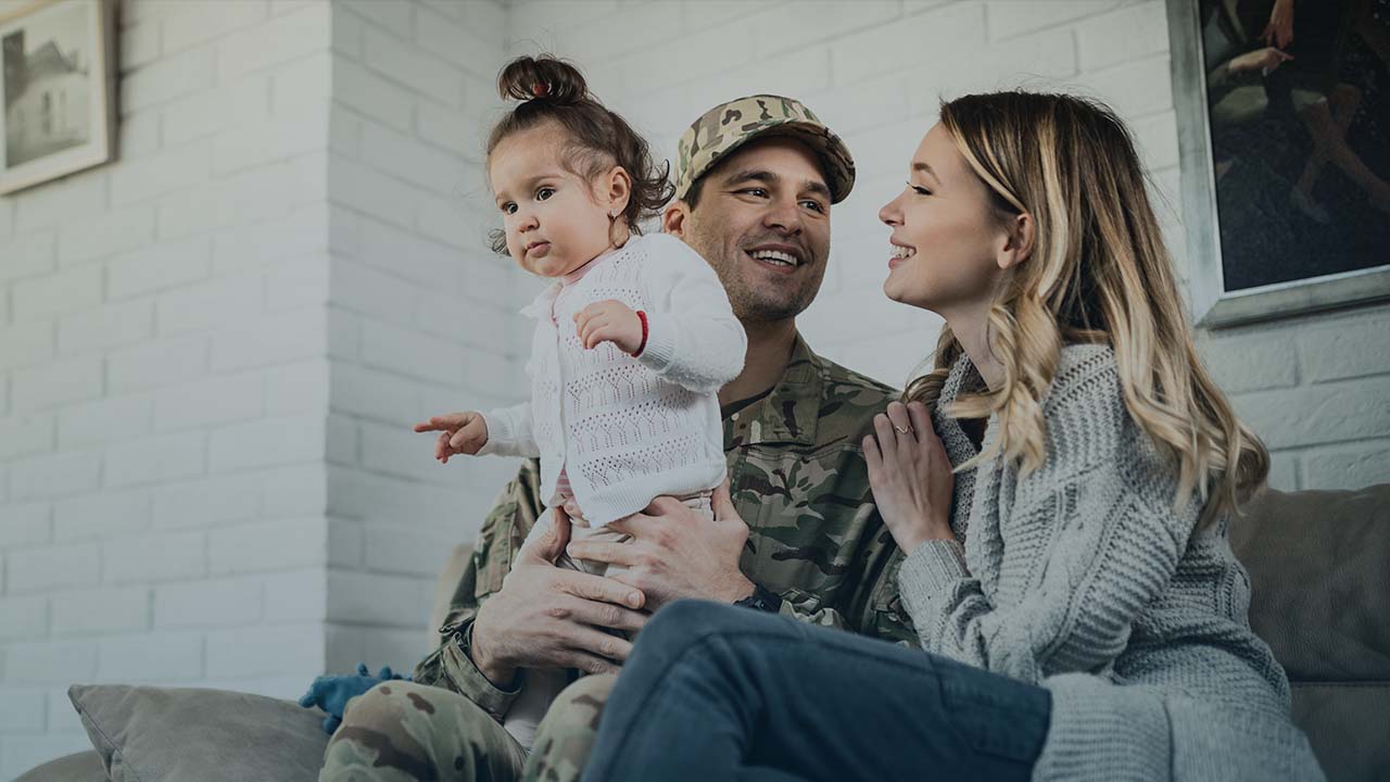 A military family of three smiles together.