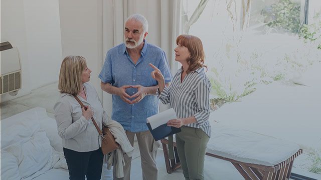 A real estate agent showing a home to an older couple.